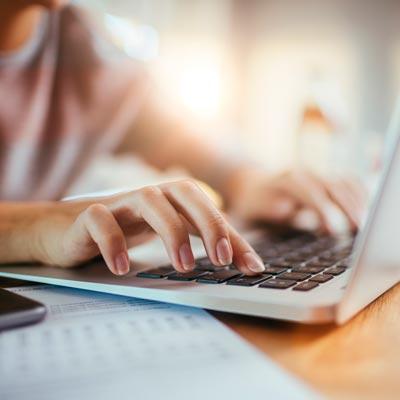 White male typing on a laptop